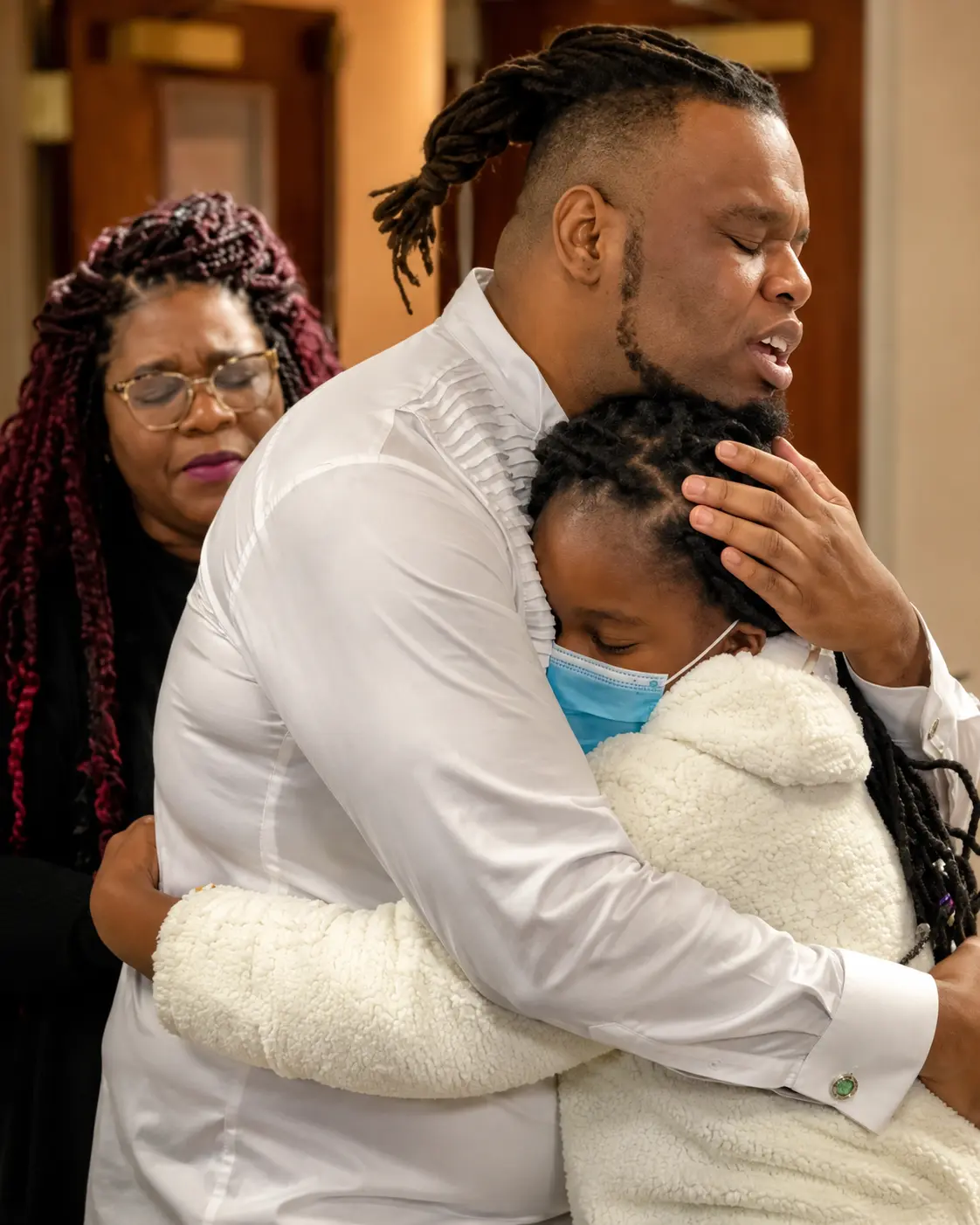 Comforting a young community member during prayer